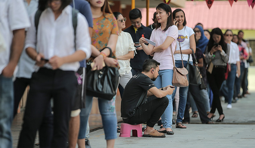 Orang ramai beratur panjang untuk membayar bil.