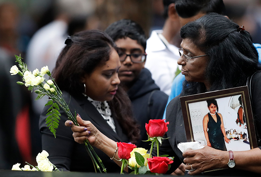 Seorang wanita meletakkan bunga di North Pool pada satu upacara memperingati ulang tahun ke-17 tragedi 9/11, di New York, 11 September, 2018. (AP Photo)