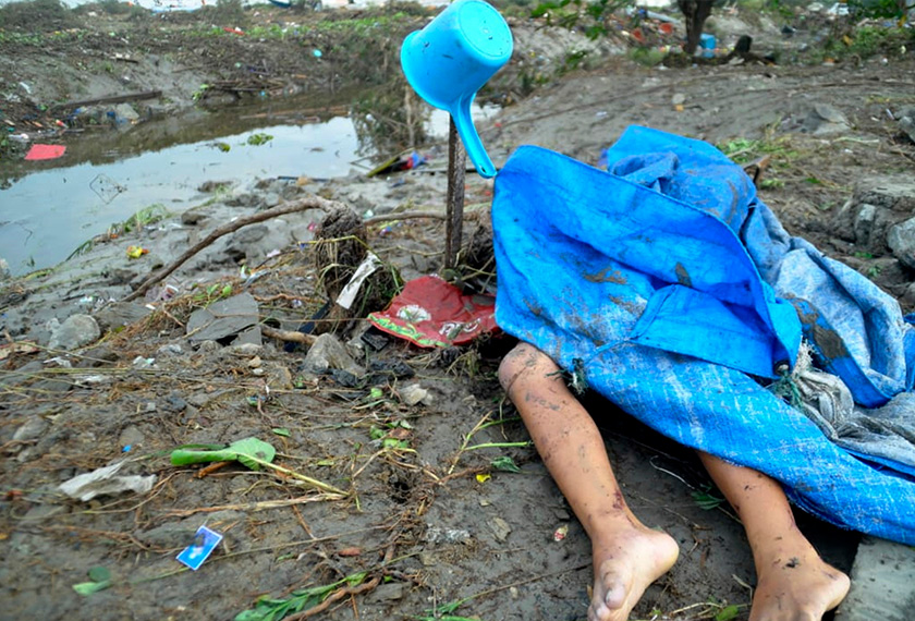 Kain menutupi mayat seorang kanak-kanak yang meninggal dunia akibat bencana tsunami di Palu, Pulau Sulawesi, Indonesia pada Sabtu. - AP
