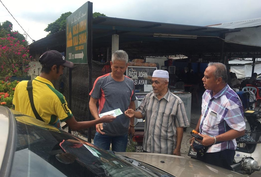 Mohd Nor mengedarkan risalah manifestonya ketika berkempen di Rantau hari ini. - Astro AWANI/Rahimah Abdullah