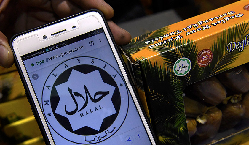 Seorang Pegawai Penguatkuasa KPDNHEP Pulau Pinang membandingkan logo halal Jakim dengan logo halal tiruan Jakim pada kotak buah kurma semasa menyerbu sebuah kilang yang membekalkan kurma di Bandar Perda hari ini. --fotoBERNAMA