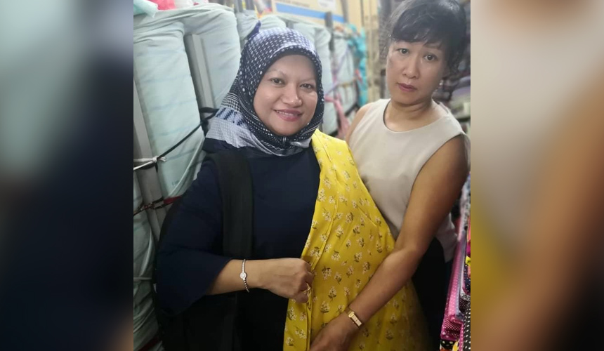 Dr Azlinariah Abdullah bersama Nguyen Vanh Bienh (kanan), peniaga tekstil wanita di Dong Xuan Market. - Foto Astro AWANI