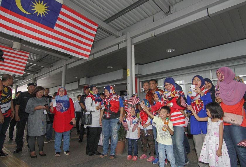 Para pengguna perkhidmatan LRT dan bas Rapid KL menyanyikan lagu Negaraku di hab pengangkutan Prasarana di Pasar Seni, Kuala Lumpur - Foto Ihsan Prasarana