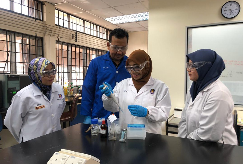 Dr. Azri memantau pelajarnya membuat penyediaan di dalam makmal.