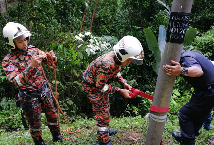 Anggota keselamatan sedang melakukan kerja-kerja menyelamat warga emas yang terbabas dalam gaung sedalam 20 meter di Tapah pada pagi Ahad. - Gambar ihsan JBPM