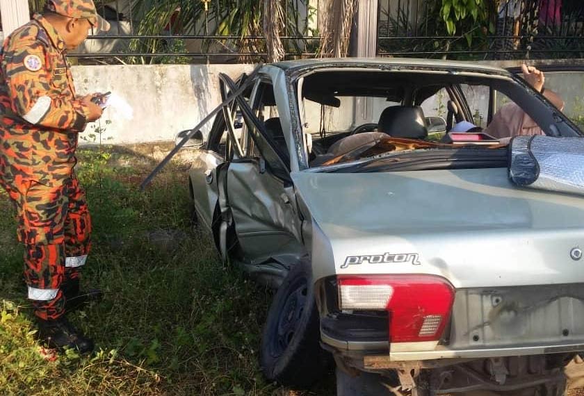Anggota bomba memeriksa keadaan kereta Proton Wira yang terlibat dalam kemalangan di Jitra pagi ini. - Foto JBPM