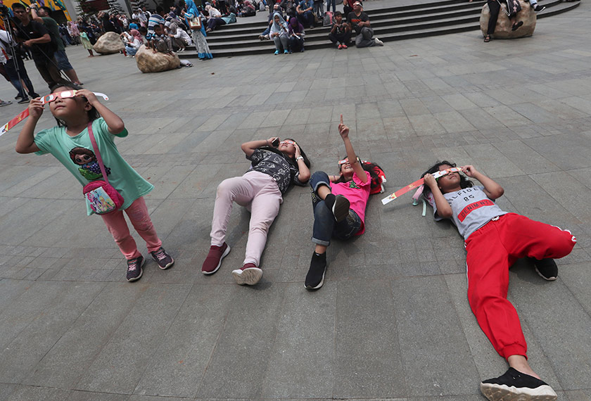 Orang ramai turut menggunakan kaca mata istimewa sambil mendongak melihat fenomena tersebut selama lebih dua minit. Foto: AP