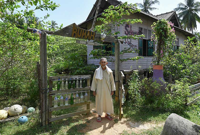 Tengku Mohd Ali berdiri di hadapan pintu pagar rumah botol di Kampung Penarik Baru, Setiu, baru-baru ini. --fotoBERNAMA