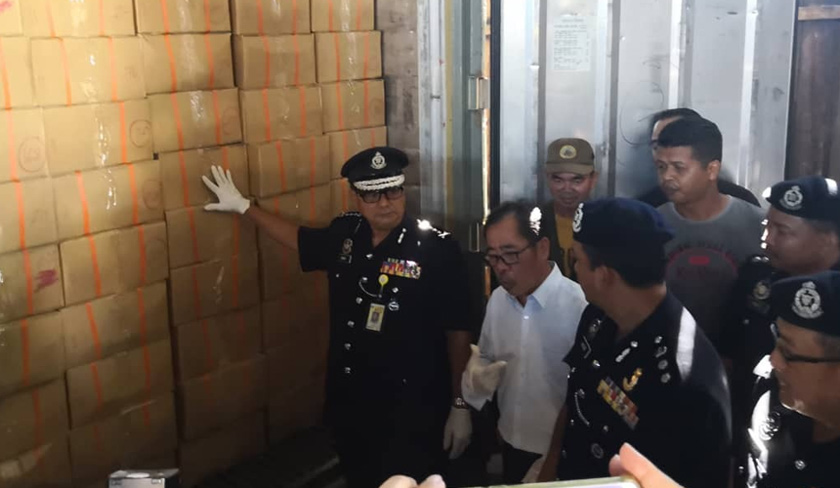 Omar (kiri) menunjukkan beberapa kotak dipercayai berisi tenggiling beku dari sebuah kontena.