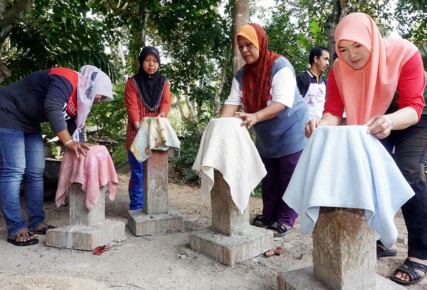 Sebahagian peserta kursus meletakkan tuala yang telah dipotong sebelum direndam dengan larutan simen ketika menghadiri kursus pembuatan pasu bunga tuala di Kampung Padang Panjang, Malau, Jitra. --fotoBERNAMA