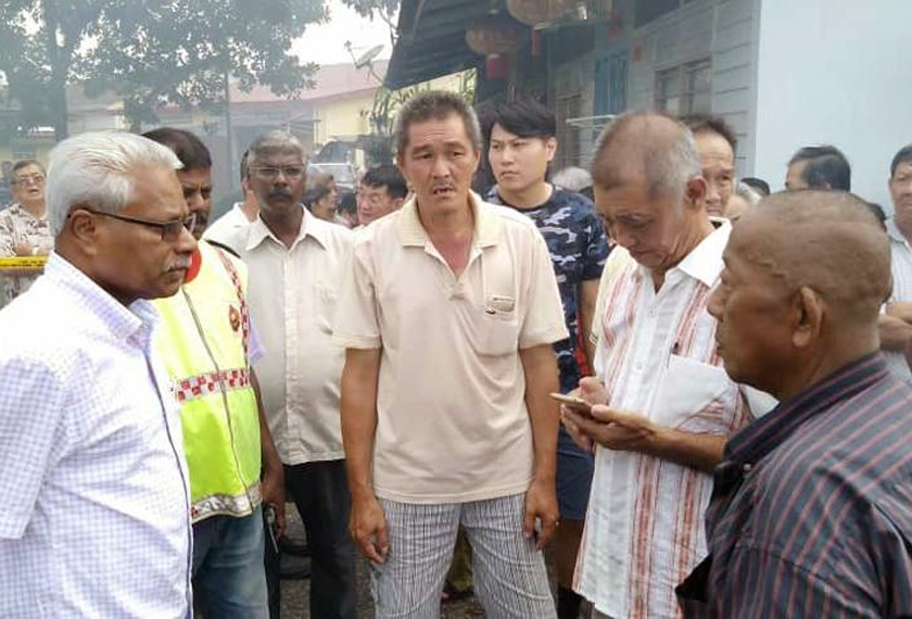 Sivanesan (kiri) bertanya khabar kepada penduduk kawasan itu. - Foto Pejabat Exco