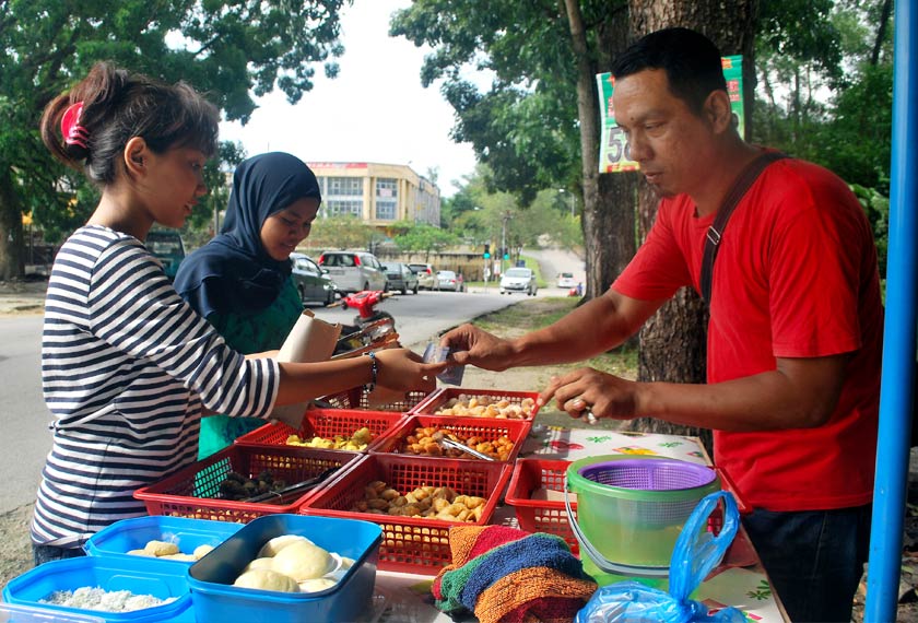 Mohd Hasmi sibuk emlayan pelanggan yang datang ke gerainya di Jalan Keranji. - Bernama