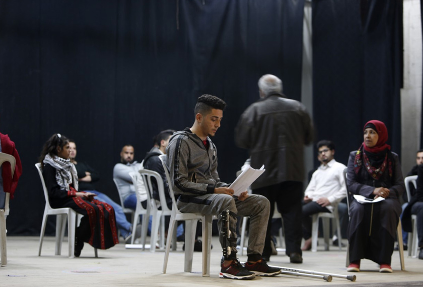 Iyad, 23, a Palestinian musician shot and wounded by the Israeli army on 14 May 2018, acts during a performance of an amateur theatre group in Gaza City, May 2019. © Mohammed ABED