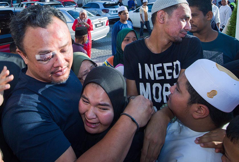 Suami arwah, Ahmad Shah menenangkan salah seorang anaknya di rumahnya di Kampung Paloh hari ini. --fotoBERNAMA