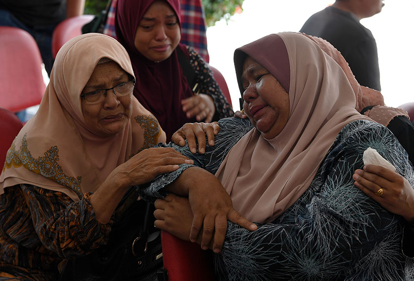 Ibu Hafiiz Mohd, Esah Abas, 66, (kiri) dan Saripah tidak dapat menahan kesedihan selepas melihat jenazah anak mereka di Jabatan Perubatan Forensik, Hospital Sultanah Nur Zahirah, Kuala Terengganu pada Sabtu. - BERNAMA