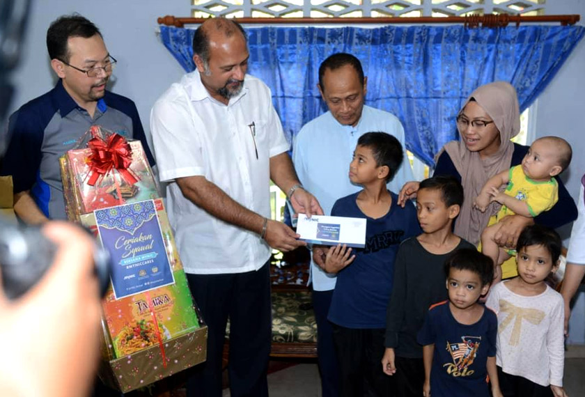 Gobind menyerahkan sumbangan wang kepada keluarga asnaf di Puchong.