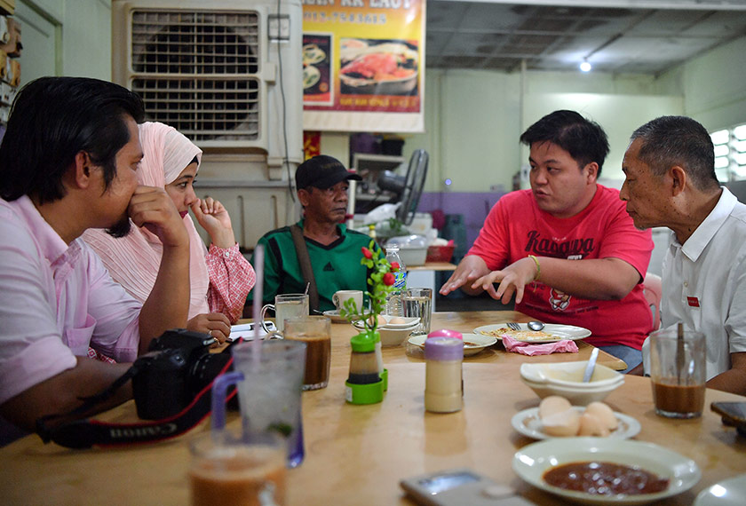 Calon PH Karmaine Sardini (kanan) mendengar keluhan penduduk setempat ketika bersarapan di Jeti Kukup. - Foto BERNAMA