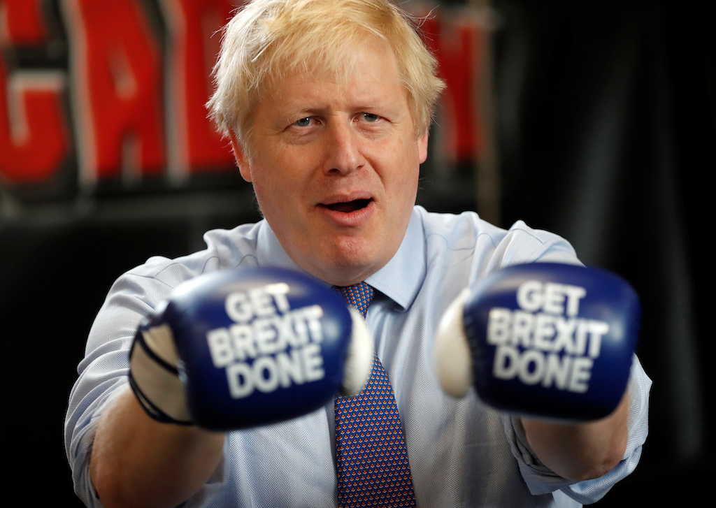 Britain's Prime Minister Boris Johnson poses for a photo wearing boxing gloves during a stop in his General Election Campaign trail at Jimmy Egan's Boxing Academy in Manchester, Britain November 19, 2019. Frank Augstein/Pool via REUTERS