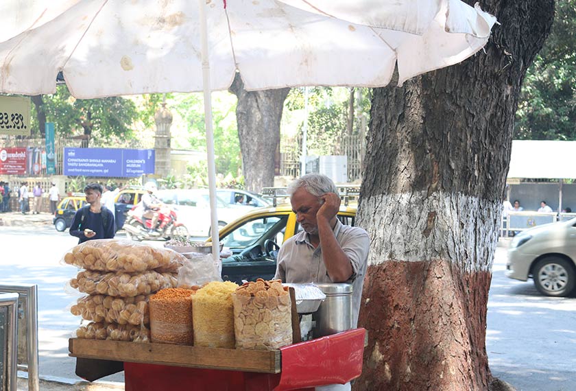 Penjaja di kaki lima menjual makanan ringan, menanti pembeli di Mumbai, India. Pasukan Ceritalah