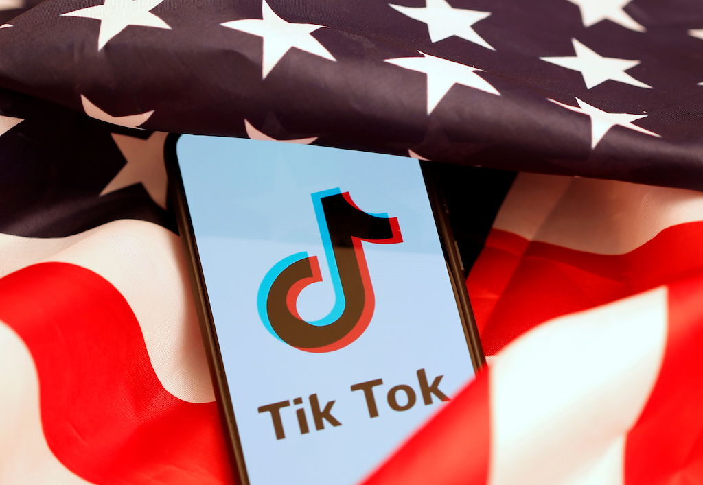 Tik Tok logo is displayed on the smartphone while standing on the U.S. flag in this illustration picture taken, November 8, 2019. REUTERS/Dado Ruvic
