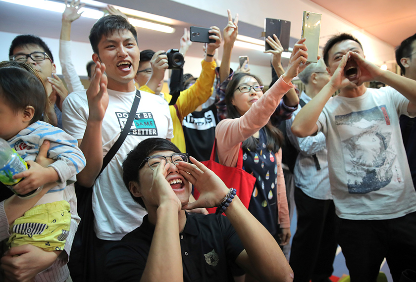 Penyokong pro-demokrasi bersorak gembira selepas ahli politik pro-Beijing Junius Ho kalah dalam pemilihan di Hong Kong, 25 Nov 2019. (Foto AP)