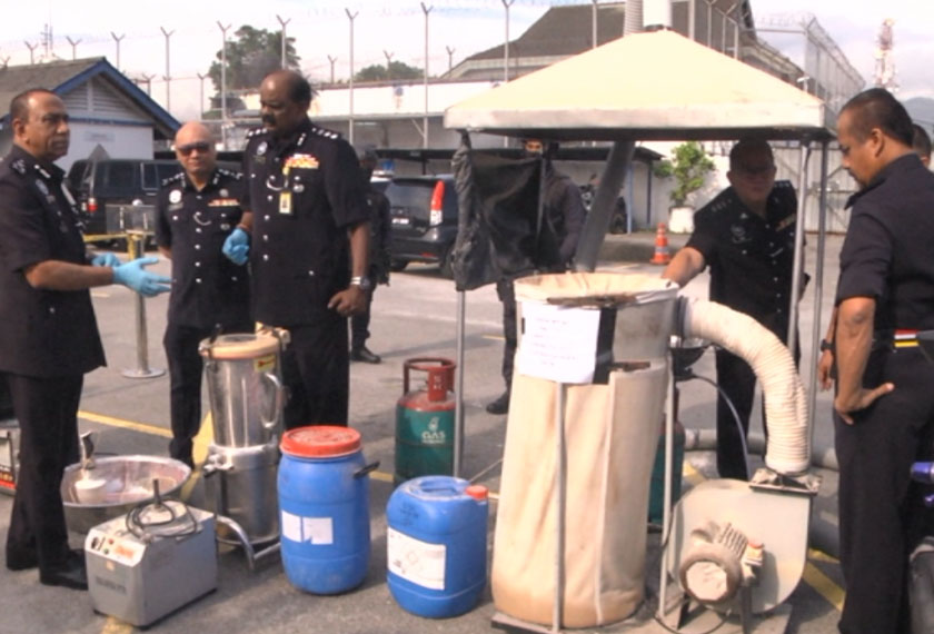 Mohd Khalil (kiri) menunjukkan antara barangan makmal yang disita. Astro AWANI