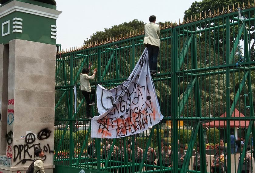 Penunjuk perasaan mengikat sepanduk pada pintu masuk utama bangunan DPR. Pasukan Ceritalah