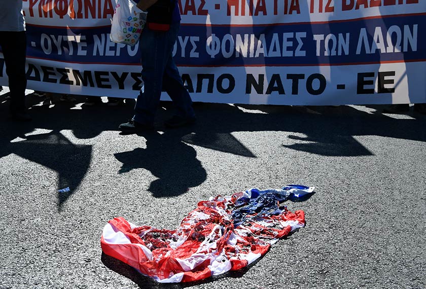 Penunjuk perasaan turut membakar bendera AS dan NATO semasa mengadakan demonstrasi menentang lawatan Mike Pompeo, di Athens, 5 Oktober 2019. (Foto AP)