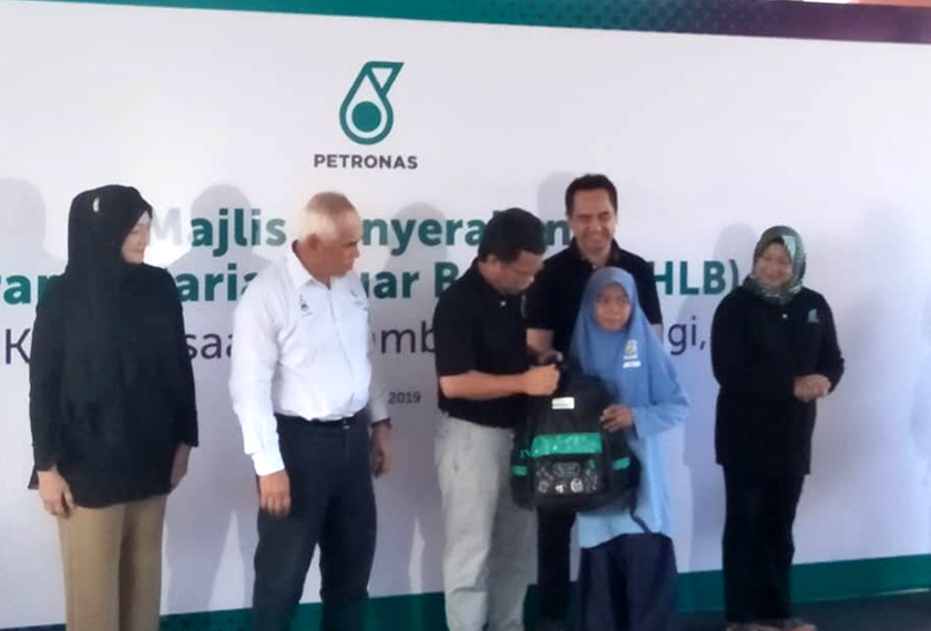 Ketua Menteri Sabah, Datuk Seri Syafie Abdal menyarungkan beg sekolah kepada pelajar SK Balambangan