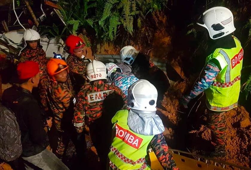 Pihak bomba sedang berusaha mengeluarkan mangsa dari runtuhan tanah. - Foto ihsan JBPM