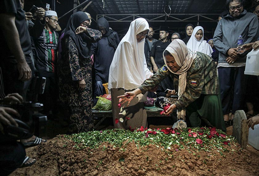 Balu Allahyarham Pitt Hanif, Farah Ahmad menabur bunga di kubur suaminya. - Gambar Astro AWANI/ SHAHIR OMAR