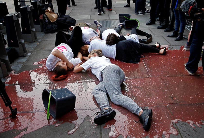 Aktivis bergelimpangan di atas simbahan cecair merah menyerupai darah. - Reuters