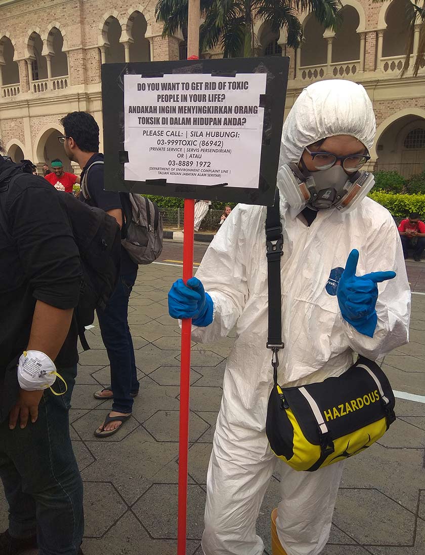 One of the participants of the MyClimateStrike at Dataran Merdeka on September 21 seen in a ‘safety-suit’ costume with a creative placard. Photo: Sathesh Raj