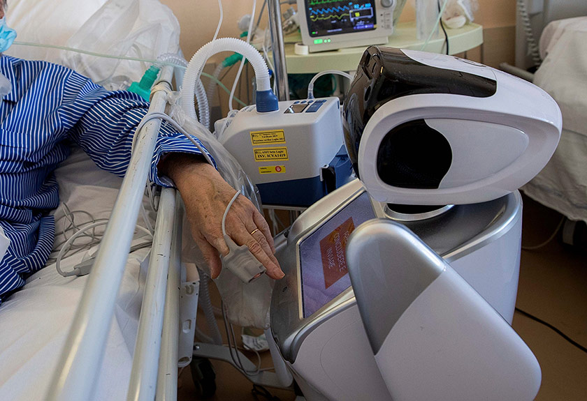 Seorang pesakit koronavirus di unit rawatan intensif berinteraksi dengan robot di Hospital Circolo di Varese, Itali, 8 April 2020. (Foto AP)