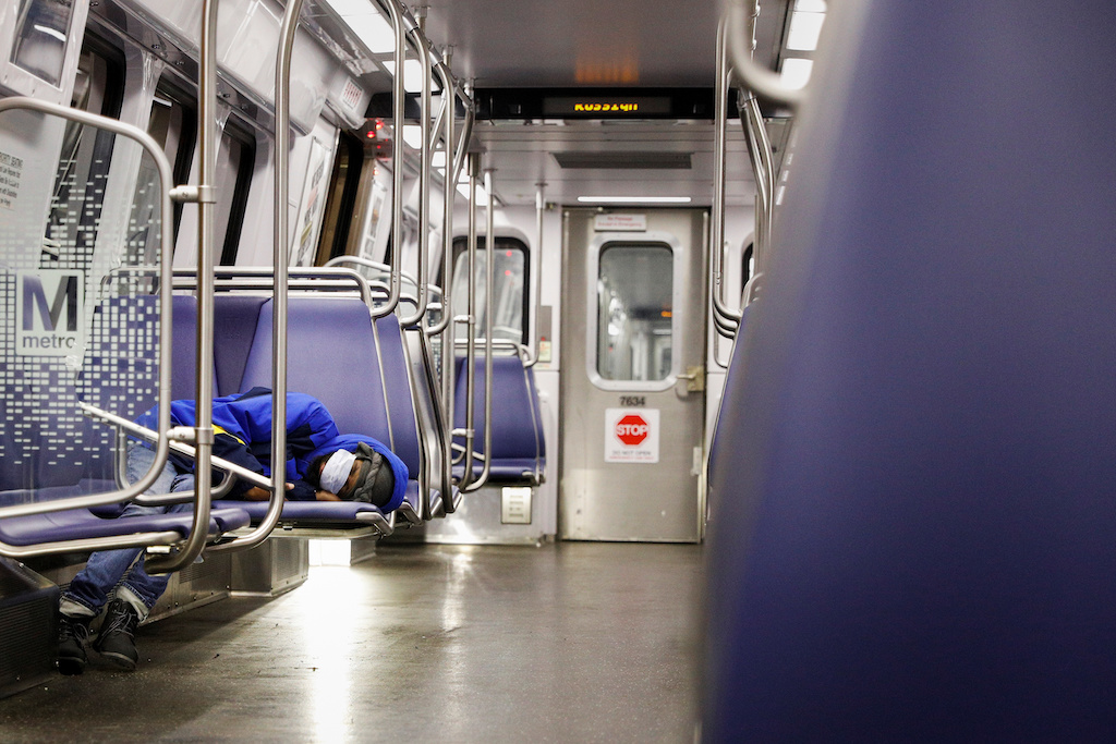 A person rests on a Washington Metro subway car wearing a face mask, following Mayor Muriel Bowser's declaration of a state of emergency due to the coronavirus disease (COVID-19) in Washington, U.S., April 13, 2020. REUTERS/Tom Brenner
