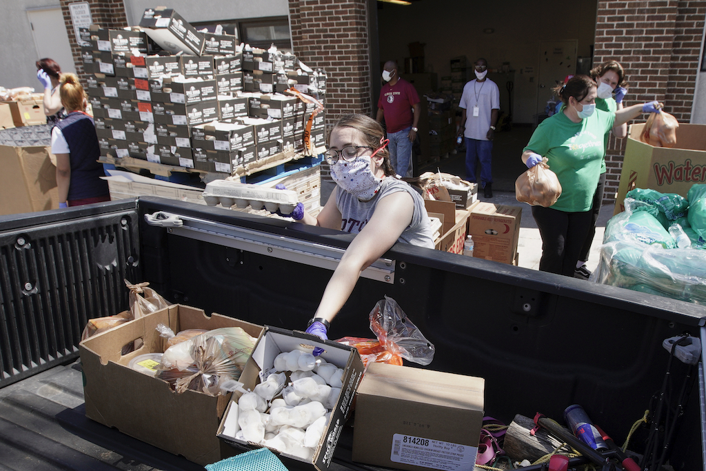 Together Omaha food pantry workers load supplies into a vehicle driving up to the pantry in Omaha, Neb., Thursday, April 23, 2020. The number of Nebraska residents seeking unemployment benefits for the first time dropped again last week but is still far higher than usual as businesses struggle with the fallout from the coronavirus. The state received 12,340 new unemployment claims during the week that ended April 18, according to the U.S. Department of Labor - AP Photo/Nati Harnik
