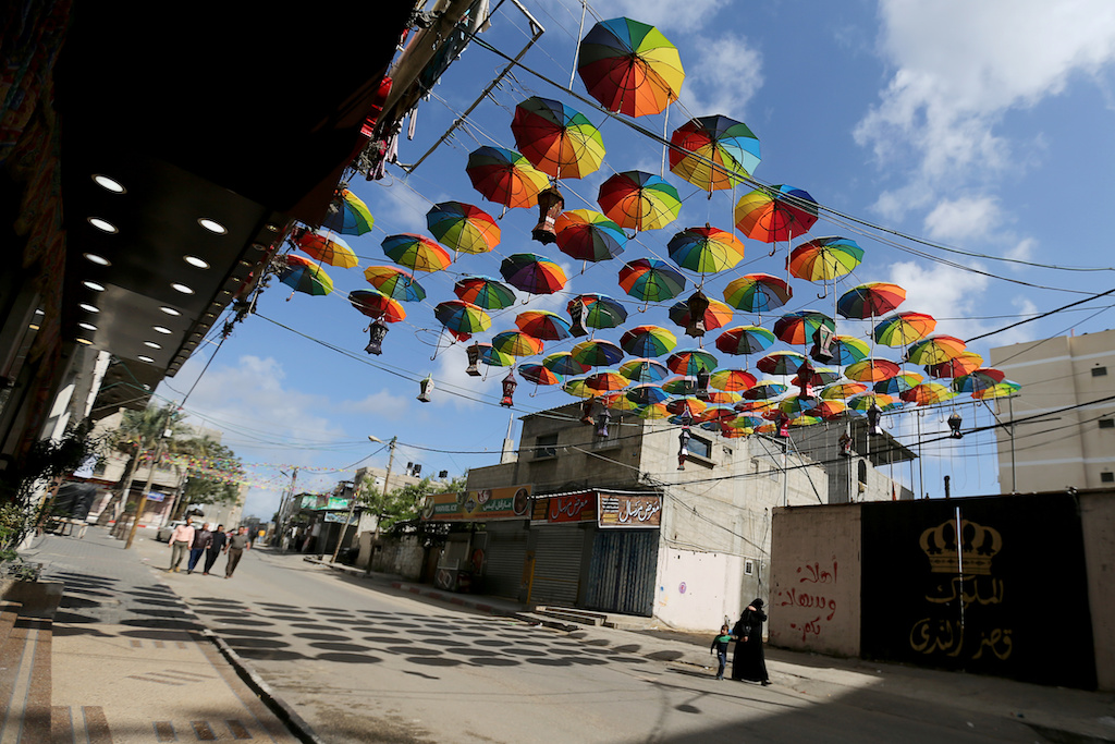 A Palestinian worker sprays water outside shops decorated ahead of the holy fasting month, amid concerns about the spread of the coronavirus disease (COVID-19), in the southern Gaza Strip April 22, 2020. REUTERS/Ibraheem Abu Mustafa