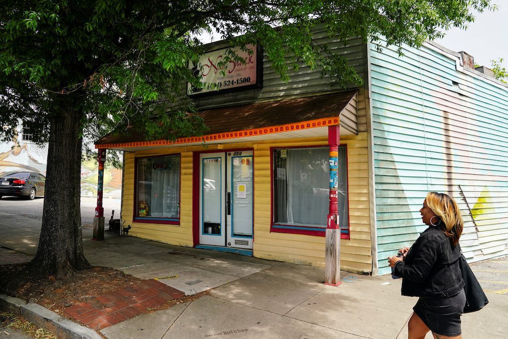 A woman passes by a nail salon days before the phased reopening of businesses and restaurants from coronavirus disease (COVID-19) restrictions in Atlanta, Georgia, U.S. April 22, 2020 - REUTERS/Elijah Nouvelage