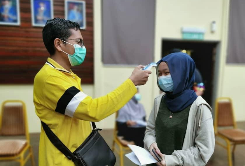 Suhu badan pelajar diambil sebelum memulakan perjalanan balik kampung. Foto UUMTV