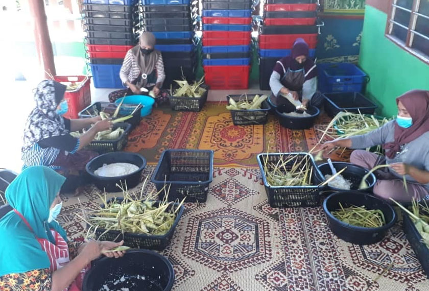 Che Non dibantu beberapa pekerja menyiapkan tempahan ketupat palas yang diterima. - Foto Astro AWANI