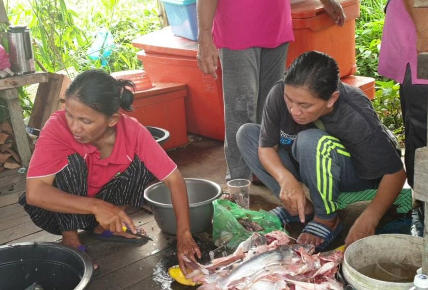 Suri rumah di Daro membersihkan ikan untuk menghasilkan juadah tradisi pipus sebelum ia dijual. -Gambar Astro AWANI
