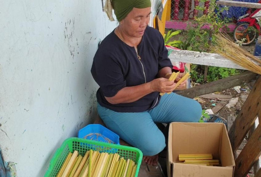 Salah seorang penduduk di Daro yang terlibat secara aktif dalam penghasilan pipus. Pipus yang siap dibalut kemudiannya akan dipanggang. -Gambar Astro AWANI