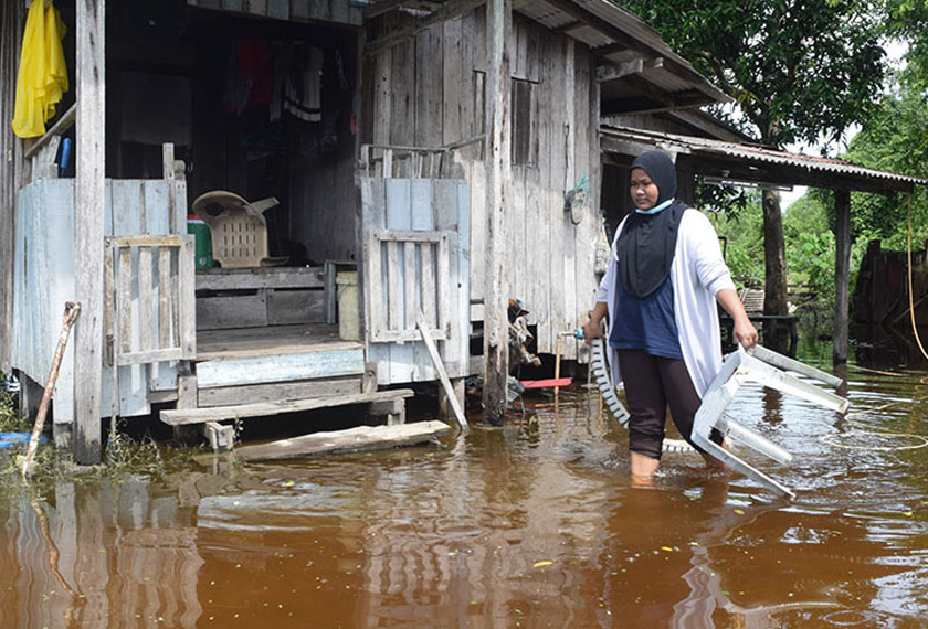 A flood victim walking in front of her house which was flooded with pensive water in Kampung Padang Garam, Marang. – foto BERNAMA