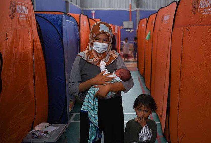 A mother and her children at one of the relief centres for flood victims. – Astro AWANI