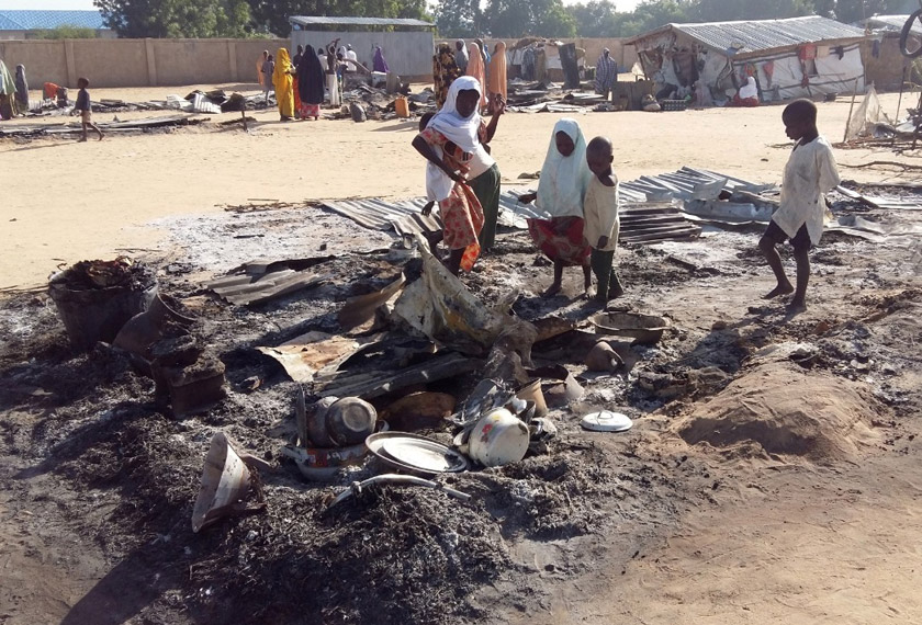 People stand amid the damage at a camp for displaced people after an attack by suspected Boko Haram insurgents in Dalori, Nigeria Nov 1, 2018. REUTERSpic