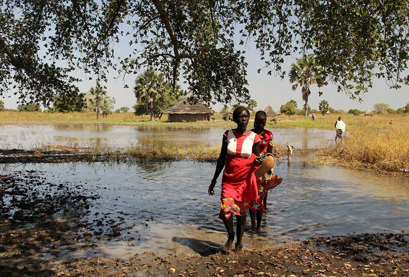 A displaced woman crosses a flooded area in Manager Ajak village, in South Sudan, November 27, 2020. - REUTERS/Denis Dumo