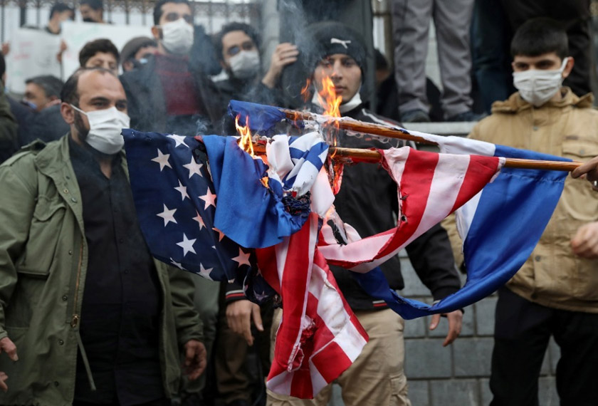 Protesters burn US and Israel flags during a demonstration against the the killing of Mohsen Fakhrizadeh, Iran's top nuclear scientist, in Tehran, Iran November 28, 2020. Image by Majid Asgaripour/WANA (West Asia News Agency) via REUTERS