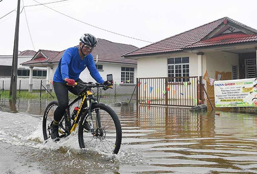 A man cycling in the flood at Kuala Nerus, Terengganu – Astro AWANI