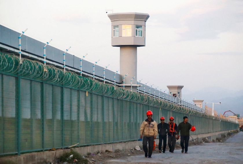 Workers walk by the perimeter fence of what is officially known as a vocational skills education centre in Dabancheng in Xinjiang Uighur autonomous region, China. REUTERS file pic