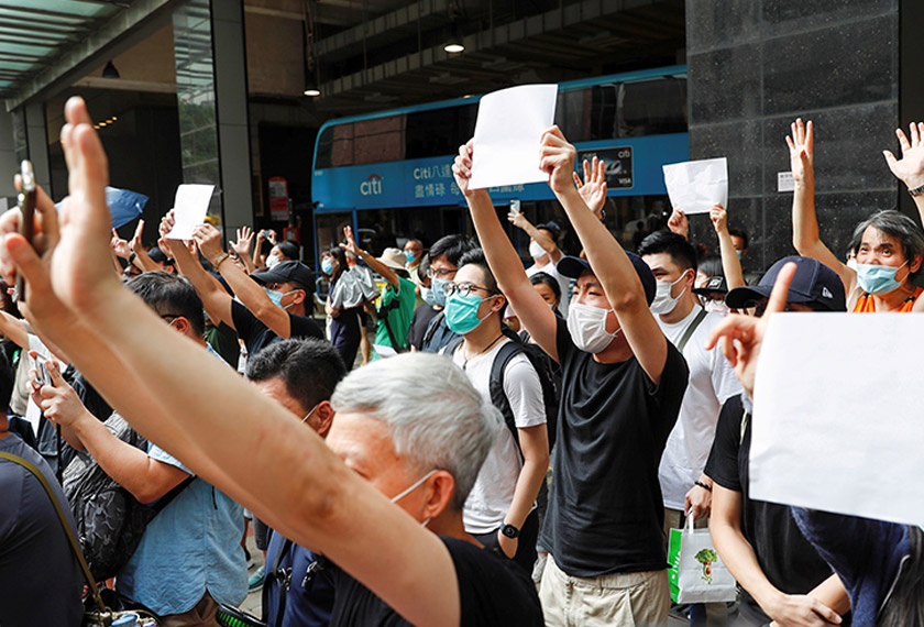 Supporters raise blank white paper to avoid slogans banned under the national security law as they support an arrested anti-law protester outside Eastern court in Hong Kong, China July 3, 2020. - REUTERS
